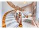 This foyer boasts soaring ceilings, a sweeping staircase, tile flooring, and a decorative rug at 241 E Country Club Dr, Henderson, NV 89015