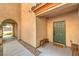 Front door and covered walkway, neutral walls, with small bench and welcome mat at 2653 Rimbaud St, Henderson, NV 89044