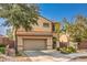 Two-story home features desert landscaping, an attached garage, and neutral stucco at 2653 Rimbaud St, Henderson, NV 89044