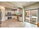 Well-lit kitchen with white cabinets, stainless steel appliances, and a sliding glass door leading to the patio at 2653 Rimbaud St, Henderson, NV 89044