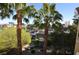 Balcony view from the condo featuring landscaping, palm trees, and city buildings in the distance at 270 E Flamingo Rd # 319, Las Vegas, NV 89169