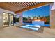 Backyard pool with water features, covered patio with wood pergola, and lush landscaping at twilight at 34 Vintage Canyon St, Las Vegas, NV 89141
