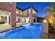 Luxury home exterior featuring a large swimming pool, stone accents, and outdoor kitchen at 34 Vintage Canyon St, Las Vegas, NV 89141