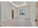 Spacious bedroom with light-colored tile floor, tray ceiling with recessed lights and modern door at 34 Vintage Canyon St, Las Vegas, NV 89141