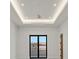 Bright living room with a tray ceiling, recessed lighting, and black framed sliding doors to the balcony at 34 Vintage Canyon St, Las Vegas, NV 89141