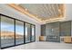 Modern living room featuring a tray ceiling, fireplace, custom cabinets with bar, and sliding glass doors at 34 Vintage Canyon St, Las Vegas, NV 89141
