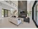 Open-concept living room featuring a sleek fireplace, soaring ceilings, and access to the outdoor patio at 34 Vintage Canyon St, Las Vegas, NV 89141