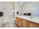 Bathroom features double sink vanity, large mirror, and shower with glass doors at 3574 Desert Cliff St # 204, Las Vegas, NV 89129