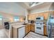 Open kitchen boasts stainless fridge, wood cabinets, light countertops, and an eat-in bar area at 3574 Desert Cliff St # 204, Las Vegas, NV 89129