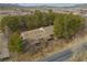 Aerial view showcases the home's roof amid lush trees, along with a street and surrounding arid landscape at 4021 Jesse St, Pahrump, NV 89048