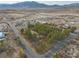 An aerial view shows a rural home amid trees near desert terrain, streets, and distant mountain range at 4021 Jesse St, Pahrump, NV 89048