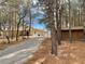 Exterior view of a home with mature trees lining the gravel driveway at 4021 Jesse St, Pahrump, NV 89048
