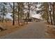 Exterior view of a home with a long driveway, surrounded by mature trees at 4021 Jesse St, Pahrump, NV 89048