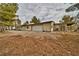 Wide exterior view of a house with a garage and long driveway, surrounded by trees at 4021 Jesse St, Pahrump, NV 89048
