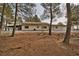 Exterior view of a home surrounded by mature trees and a gravel driveway at 4021 Jesse St, Pahrump, NV 89048