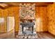 Cozy living room stone fireplace with wood paneling and hardwood flooring at 4021 Jesse St, Pahrump, NV 89048