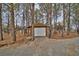 View of a detached garage with a white door surrounded by mature trees at 4021 Jesse St, Pahrump, NV 89048