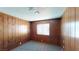 Cozy bedroom with rustic wood paneling features a window for natural light and plush carpet at 4712 Primavera St, Las Vegas, NV 89122