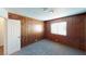 Bedroom with plush carpet and rustic wood paneling features a window for natural light at 4712 Primavera St, Las Vegas, NV 89122