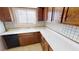 Well-lit kitchen featuring tile flooring, plentiful cabinetry, and white countertops at 4712 Primavera St, Las Vegas, NV 89122