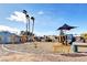 Community playground features swings, slides, and shade with tall palm trees in the background at 4712 Primavera St, Las Vegas, NV 89122