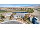 Aerial view of single-story home, golf course frontage, lake, desert landscaping, and mountain views at 4924 E Cactus Canyon Dr, Pahrump, NV 89061