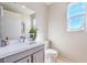 Clean bathroom featuring modern fixtures, a toilet, vanity with sink, and a bright window providing natural light at 4924 E Cactus Canyon Dr, Pahrump, NV 89061