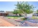 Single-story home featuring a beautiful front yard, mature shade trees, manicured lawn and charming brick wall at 5109 Sugarfoot Ave, Las Vegas, NV 89107