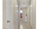 Well-lit hallway with tile flooring, white doors, and access to various rooms at 5109 Sugarfoot Ave, Las Vegas, NV 89107