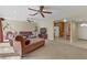 Comfortable living area featuring neutral carpet, ceiling fan, and seamless flow into kitchen at 5109 Sugarfoot Ave, Las Vegas, NV 89107