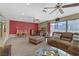 Spacious living room with plush seating, ceiling fans, and sliding glass doors for natural light at 5109 Sugarfoot Ave, Las Vegas, NV 89107