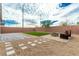 Backyard featuring artificial grass, gravel, pavers, fire pit, and bench at 5147 Stonecrop St, North Las Vegas, NV 89031