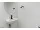 Modern bathroom with a sleek pedestal sink and a round mirror at 5147 Stonecrop St, North Las Vegas, NV 89031