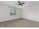 Bright bedroom with carpet, ceiling fan, and a large window for natural light at 5147 Stonecrop St, North Las Vegas, NV 89031