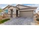 Charming single-story home featuring a paver driveway, neutral stucco, stone accents, and a two car garage at 5147 Stonecrop St, North Las Vegas, NV 89031