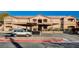 Tan apartment building with covered parking, landscaping, and parking spots at 5751 E Hacienda Ave # 172, Las Vegas, NV 89122