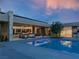 Backyard at dusk with a pool, covered patio, and multiple living areas at 6 Rockmount Ct, Henderson, NV 89012