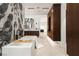 Bathroom with large tub, marble accent wall, wood cabinets, and modern finishes at 6 Rockmount Ct, Henderson, NV 89012