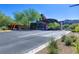 Community entry gate with desert landscaping and lush green trees in the background at 6 Rockmount Ct, Henderson, NV 89012