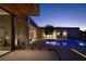 A modern home's exterior is beautifully illuminated at night, showcasing its elegant design and inviting outdoor spaces at 6 Rockmount Ct, Henderson, NV 89012