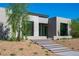 Exterior of modern home with stone and stucco accents with desert landscaping at 6 Rockmount Ct, Henderson, NV 89012