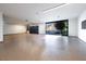 Spacious garage with epoxy floor, storage cabinets, and large glass door to the backyard with an outdoor view at 6 Rockmount Ct, Henderson, NV 89012