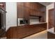 Kitchen with dark brown cabinets, stainless steel microwave and a marble countertop at 6 Rockmount Ct, Henderson, NV 89012