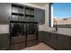 Modern laundry room with gray cabinets, stainless steel appliances, a sink, and a window at 6 Rockmount Ct, Henderson, NV 89012