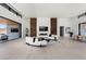Spacious living room with a modern fireplace, wood accent wall, white sofas, and an open door to the patio at 6 Rockmount Ct, Henderson, NV 89012