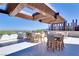 Outdoor dining area with shade structure, chairs, tables, city views, and couches in the background at 6 Rockmount Ct, Henderson, NV 89012