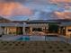 Backyard view of modern home with a pool overlooking mountains during a colorful dusk sky at 6 Rockmount Ct, Henderson, NV 89012