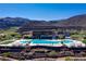 Aerial view of the community pool nestled in the mountains with stunning desert landscaping all around at 6 Rockmount Ct, Henderson, NV 89012