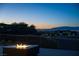 Stunning backyard view featuring a modern fire pit and city views on the horizon at dusk at 6 Rockmount Ct, Henderson, NV 89012