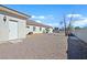 A gravel-covered backyard with mature trees and a block wall at 6120 Farm Rd, Las Vegas, NV 89131
